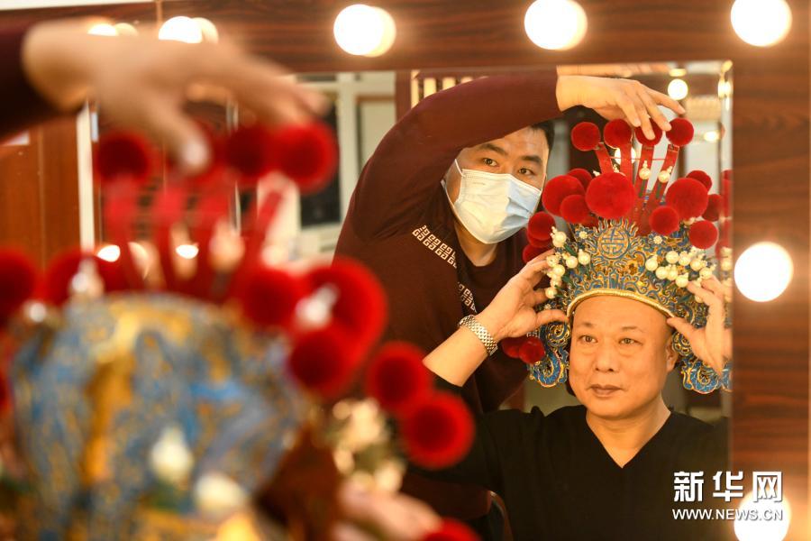 3月16日,戏曲盔头制作维修师朱宝辉(左)在河北省石家庄大剧院后台为