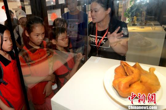 来自马祖的小营员被在福州三坊七巷非遗博物馆展出真假难辨的寿山石雕作品《卤鸭》吸引。　记者刘可耕 摄