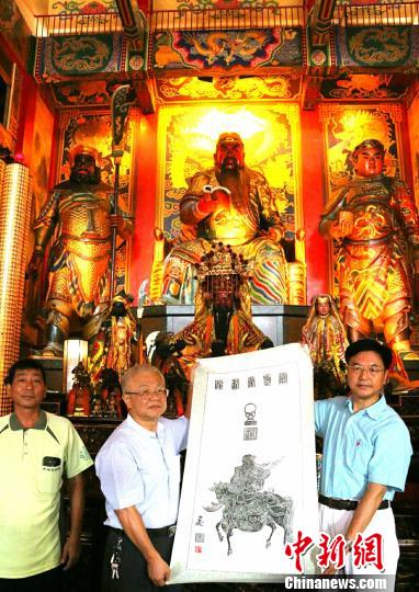 10月18日，朱正明(右)向高雄关帝庙主委黄富浓(中)赠送岳飞画关公古碑拓片 钟新 摄