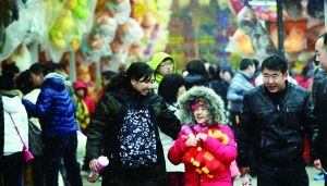昨天，在北京石景山游乐园，游客在雪中逛庙会。 　　首席摄影记者　蔡代征/摄