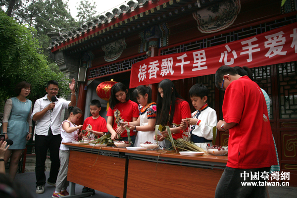 31日下午，来自台北兴隆小学的小学生与北京黄城根小学的同学们一起欢迎端午节。图为两岸的小朋友包粽子