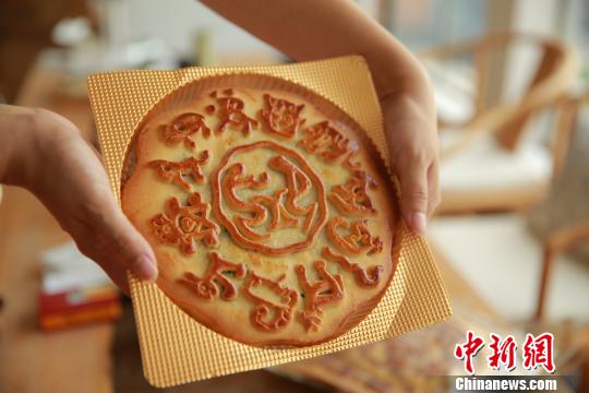 台湾象形文字专家麦智明推出象形月饼，古老的象形文字“享”在中间，四周围绕着十二生肖的象形文字。 董子畅 摄