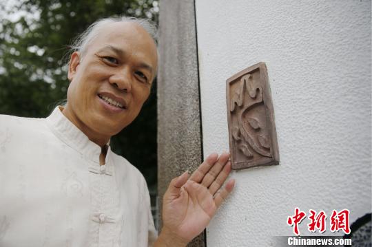 6月30日，台湾艺术家陈逢显向记者介绍新北市新店区与乌来区交界处龟山桥头石碑上的书法艺术。图为石碑上由陈逢显创作的砖雕。　陈小愿 摄